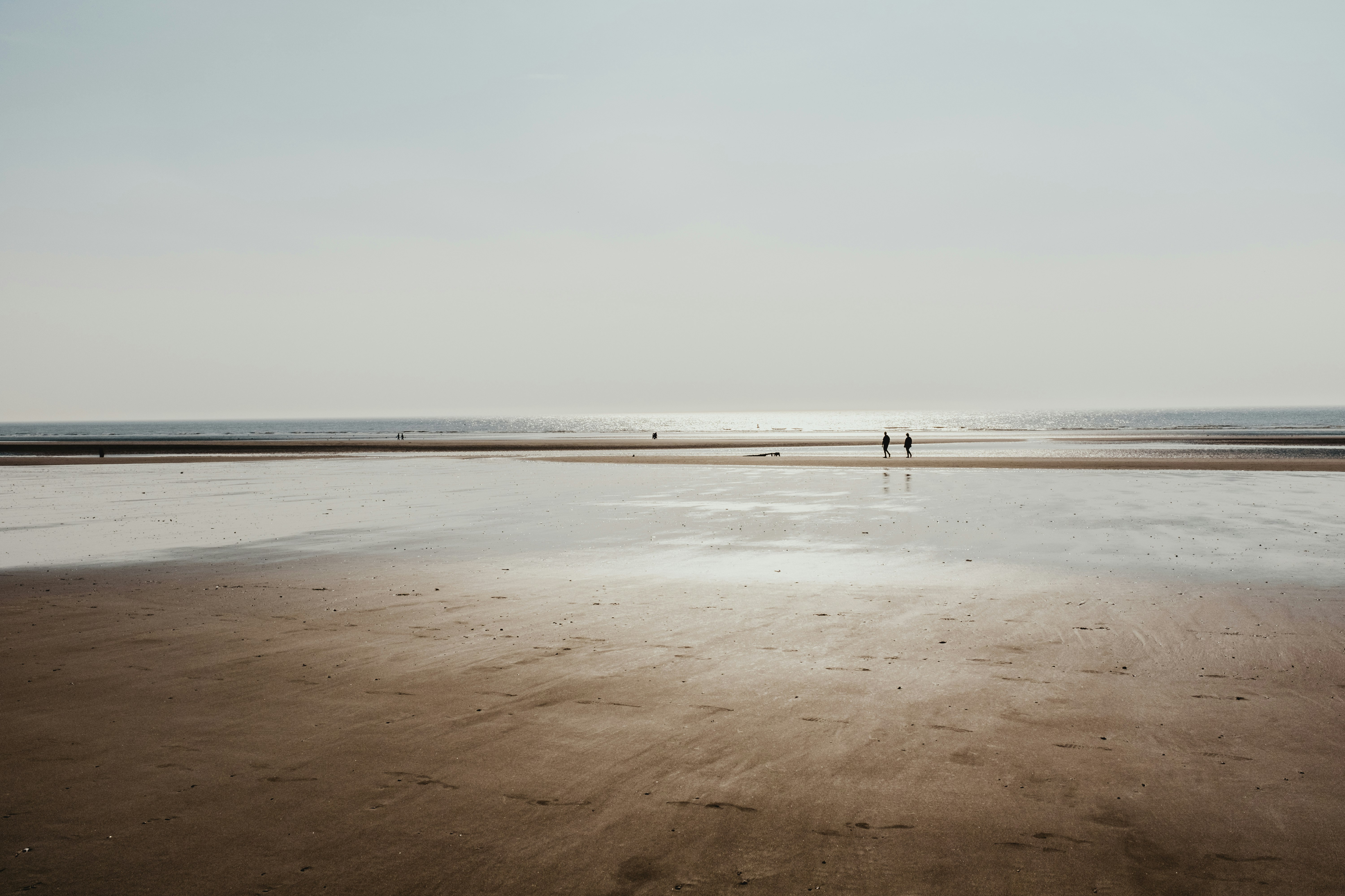 two people standing on shore during golden hour